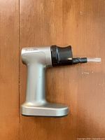 Left side view of the smoker showing silver handle and black smoke chamber