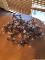 Coiled brown-cord string light with many clear globe bulbs on tabletop