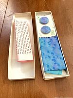 Entire set in two open boxes showing scarf, accessories, care sheet