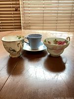 Front view of three teacups and one saucer