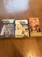 Front view of all three media items: Beetlejuice VHS, Hannah Montana DVD, Dirty Dancing VHS