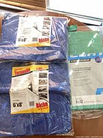 All three packaged tarps showing sizes and colors