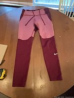 Front view of Nike burgundy and pink leggings with drawstring waist