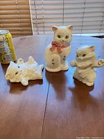All three cat figurines with soda can for scale