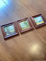 All three framed oil landscape paintings laid side by side