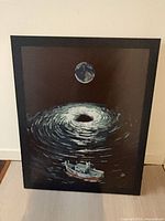Full view of framed print showing boat, swirling water and moon