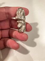 Angled view of the sterling silver abstract face figurine held in hand