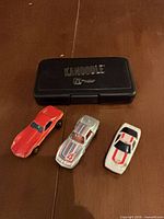Kanoodle closed case and three diecast cars top view