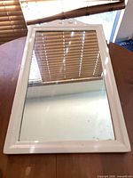 Front view of mirror showing off-white frame and glass panel