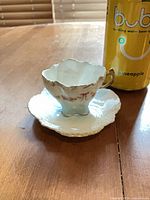 cup on saucer next to can showing overall design and size