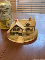 Front view of miniature house with can for scale