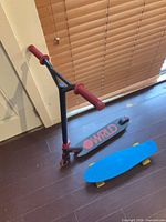 WRLD scooter standing beside blue cruiser board