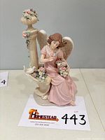 Front three-quarter view of porcelain angel figurine on bench