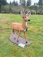 Front left view of full concrete deer statue on base