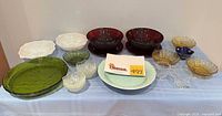 Overview of all coloured glass and porcelain serving items on table