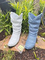 Front view of both concrete cowboy boot planters showing colors, size reference tag 622