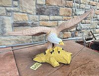 Front view of concrete eagle statue on yellow branch base