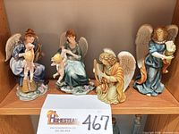 All four porcelain angel figurines on shelf