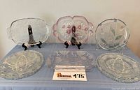 All six pressed-glass trays displayed on table