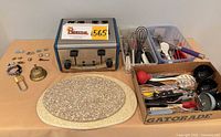 Group shot showing toaster, cutting boards, utensils, jewelry, bell, padlock