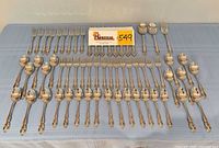 Full view of entire 62-piece flatware set laid out on table