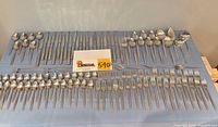 Full layout of all flatware pieces on table with lot card visible
