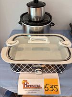 Front view showing all three stacked cookers, lids visible