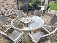 Full view of round glass table with six swivel rocker chairs