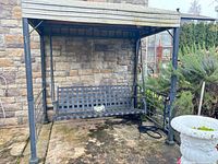 full view of patio swing within frame against stone wall