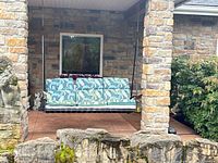 Front view of entire porch swing under stone porch