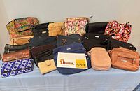 Overall view of entire assortment of purses, bags, clutches and wallets on table
