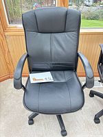 Full view of black office chair from front showing seat, back, arms and base
