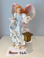 Front view of angel figurine with lantern and wings displayed