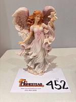 Front view of Vanessa angel figurine standing on table