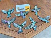 All seven hummingbird figurines displayed on tabletop