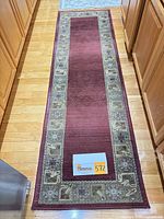 Full view of red Oriental Weavers Sphinx runner rug on hardwood floor