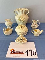 full lot group on table showing all seven ivory porcelain pieces