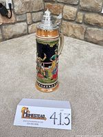 Full view of beer stein showing height and relief scene