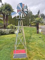 Full view of painted metal windmill showing tower and vane