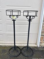 Two black wrought iron plant stands full view