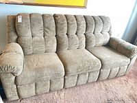 Front view of three-seat beige fabric reclining sofa