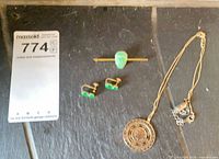 All items laid out: necklace, earrings pair, stick pin