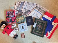 overview of entire lot: plush guard, tins, newspapers, flag, books, box