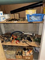 Shelf with basket of files, black pipe, boxed filters, mixed tools and hardware