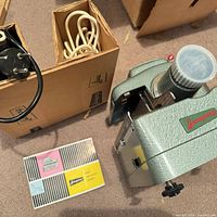 Projector with cords, booklet and boxes on floor