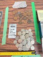 Full lot view showing coin purse, copper coins, silver-tone shilling pile