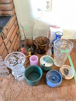 Group shot of all vases, bowls, candle holders and ceramic pieces arranged on carpet