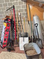 Full lot showing grouped garden tools, shovels, rakes, tubs, Toro box