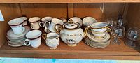 All pieces on shelf: cups, saucers, plates, teapot, sugar bowl, creamer