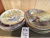 Stacks of decorative plates showing bird and landscape imagery
